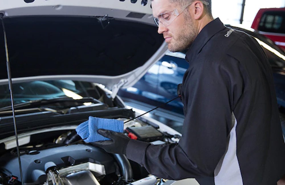 Service technician checking vehicle oil