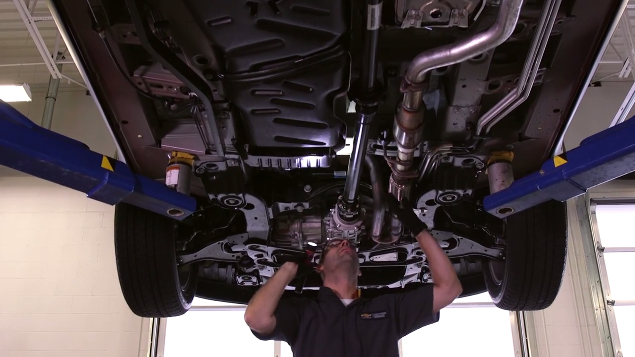 Service technician working under the hood of a car.