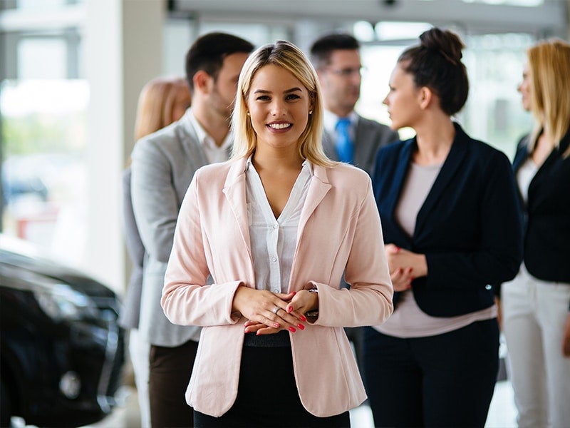 Smiling businesswoman standing in front of a group.